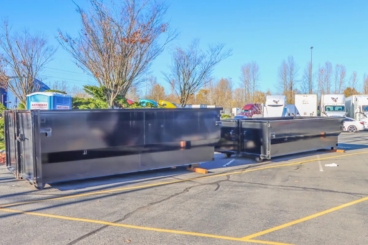 Professional dumpster rental service with roll-off container on residential driveway in Lander